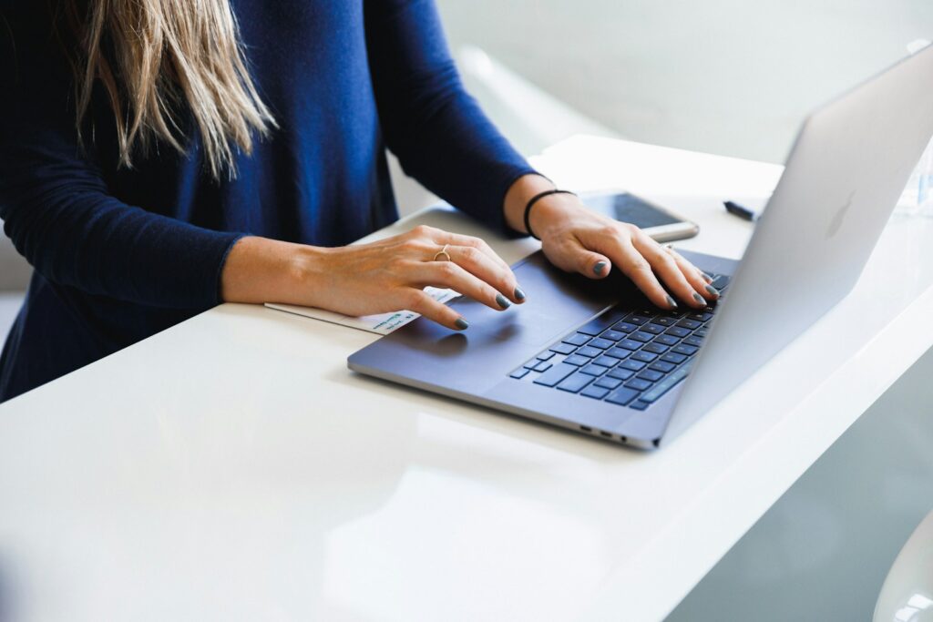 Social media manager working on a laptop, comparing the cost of an in-house hire with a Dubai agency