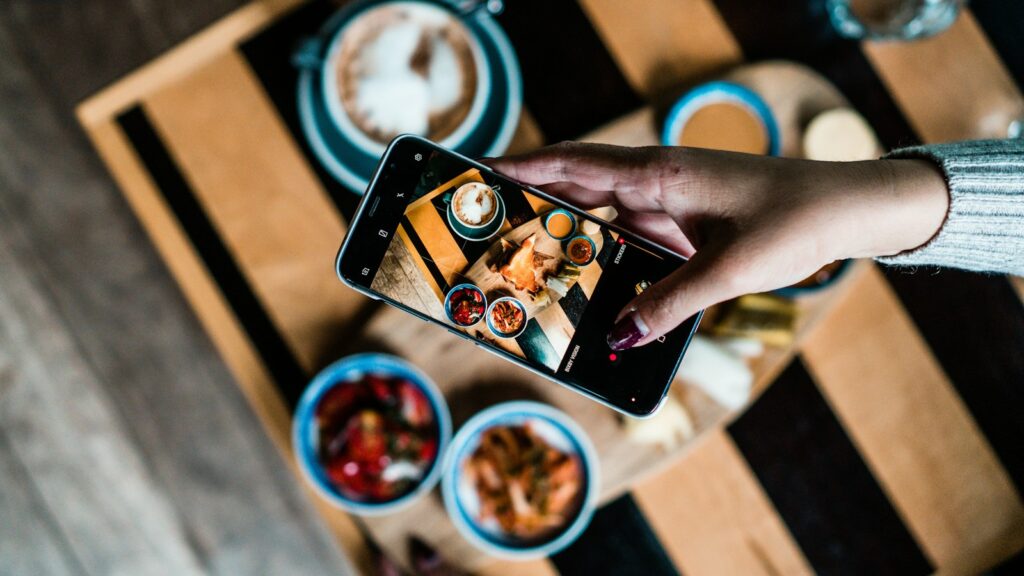 Person filming content on a phone, for a guide on why Instagram reach is low in 2026